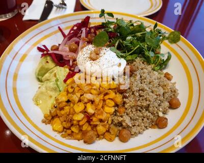 Insalata fresca con avocado, barbabietola, cipolla rossa, ceci, prezzemolo fresco e olio d'oliva garlicky e condimento al limone. Un uovo in camicia aggiunto sulla parte superiore. Foto Stock