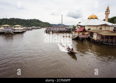 Bandar seri Begawan / Brunei - 16 gennaio 2019: Vista panoramica della barca lungo il canale d'acqua con la moschea nel villaggio galleggiante Kampong Ayer nella capitale di Brueni Foto Stock