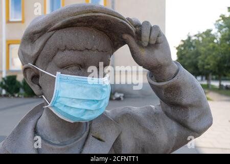 Ritorno a scuola per bambini e studenti durante COVID-19 o l'epidemia di Coronavirus, ritorno a scuola con nuove regole, statua di bambino che indossa una maschera Foto Stock