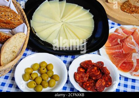 Selezione di tapas, pane rustico, formaggio Manchego, Jamon Serrano (salame di carne), chorizo, olive verdi, Costa del Sol, Andalusia, Spagna, occidentale Foto Stock