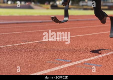 Sezione bassa dell'atleta maschile con gambe protesiche in corsa Foto Stock
