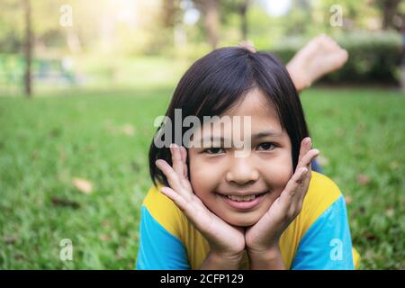 Le ragazze asiatiche sorridono felicemente sul prato. Foto Stock