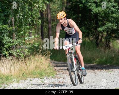 Raddanec, Czechia - 23 agosto 2020. L'evento triathlon Samuel XC. L'adolescente pilota gira a destra su strada forestale e tiene premuti i freni delicati. Foto Stock