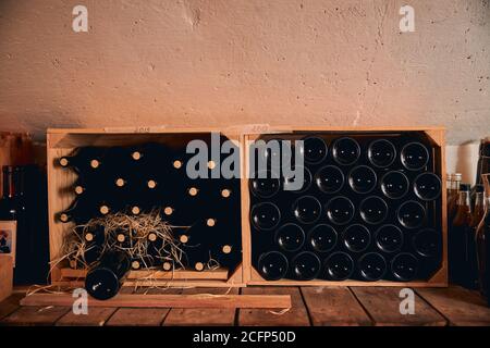 Cantina con bottiglie di vino in gabbie di legno Foto Stock