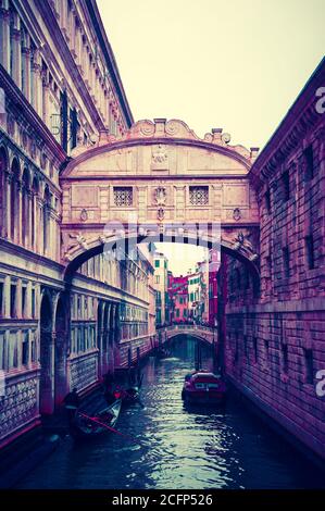 Gondole galleggianti sul canale verso il Ponte dei Sospiri. Venezia, Italia. Prospettiva. Foto scura a toni. Foto Stock