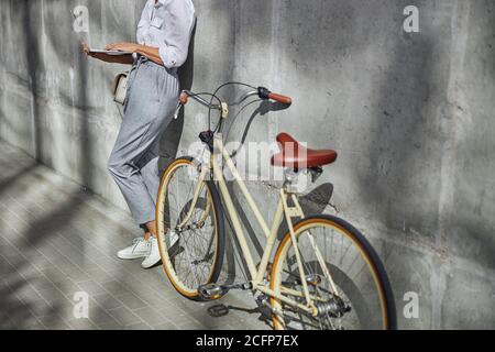 Donna che passa il tempo in città con la bicicletta Foto Stock