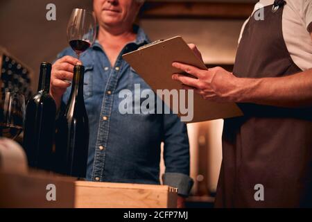 Sommelier professionisti che valutano il vino rosso e fanno note Foto Stock