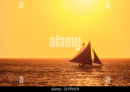 Boracay, Filippine - 23 gennaio 2020: Tramonto sull'isola di Boracay. Vela e altre barche tradizionali con turisti sul mare sullo sfondo di Foto Stock