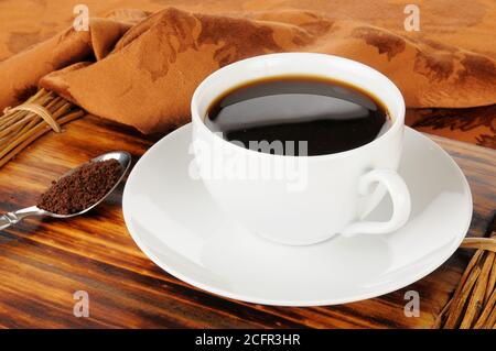 Una tazza di caffè istantaneo con un cucchiaio di granai Foto Stock