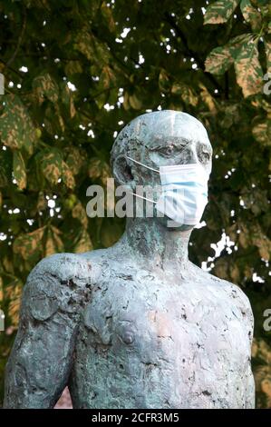 Un dettaglio della scultura dei martiri del Dorset di Dame Elizabeth Frink, che mostra una statua che indossa una maschera chirurgica durante la pandemia del Covid 19. Inghilterra. Foto Stock