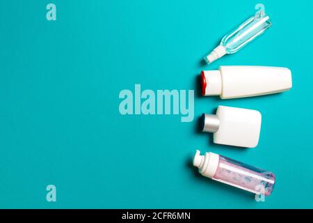 Set di contenitori di personalizzazione bianchi isolati su sfondo colorato, vista dall'alto con spazio di copia. Gruppo di contenitori in plastica per bottiglie per la cura della carrozzeria con spac vuoto Foto Stock