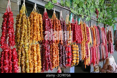 Dolci tradizionali georgiani colorati chiamati Churchkhela esposti su un mercato Stallo Foto Stock