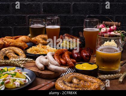 Piatti Oktoberfest con birra, pretzel e salsiccia Foto Stock