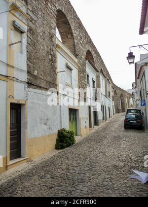 EVORA, PORTOGALLO - 06 ottobre 2010: Evora, Portogallo, 2010 ottobre: Case costruite negli archi di Aqueduto da agua de Prata a Evora, Portogallo Foto Stock