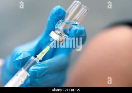 Biologia e scienza. Medico che tiene una siringa, che dà la vaccinazione. Avviso globale. Vaccinazione. Influenza. Covid-19. Coronavirus. Ricerca. Foto Stock