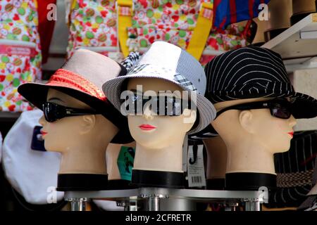 Mazzo di teste di manichino che indossano cappelli da sole e occhiali da sole da un negozio di souvenir Foto Stock