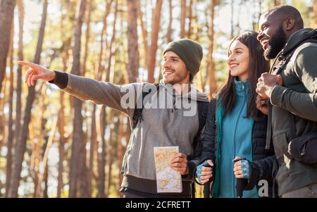 Gli escursionisti felici hanno trovato la strada giusta, tenendo la mappa alla foresta Foto Stock