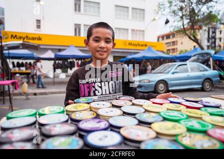 Kota Kinabalu / Malesia - 13 gennaio 2019: Giovane ragazzo che vende smalto scarpe su stalla di strada Foto Stock