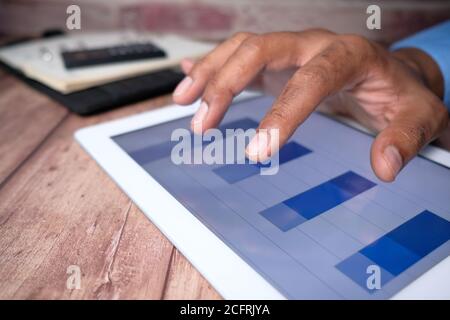 primo piano della mano di un uomo d'affari che analizza il grafico a barre su digitale tablet Foto Stock