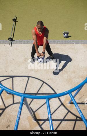 Uomo con gamba protesica che si sta allenando utilizzando il bicchiere del bollitore il parco Foto Stock