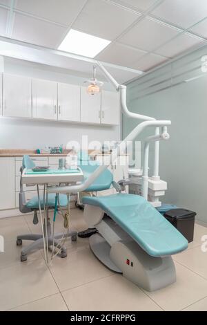 bella sedia da ufficio dentale verde con strumenti medici intorno, primo piano Foto Stock