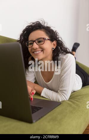 bella donna che lavora a casa con un computer, lavorando con la distanza sociale Foto Stock