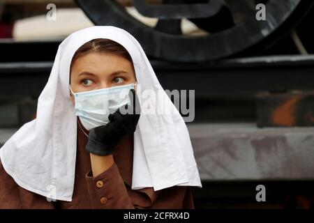 Infermiera di inizio 20 ° secolo in maschera di fronte vicino all'ospedale militare campo durante il giorno della città di Mosca. Ricostruzione storica della prima guerra mondiale Foto Stock