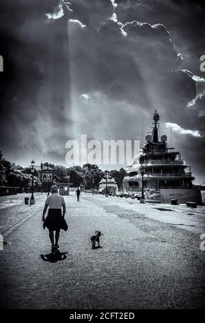 Atmosfera intorno al Festival Internazionale del Cinema di Venezia lunedì 7 settembre 2020 ai Giardini della Biennale di Venezia. Un uomo che cammina il suo cane sul lungomare sulle strade bagnate. Foto di Julie Edwards. Foto Stock