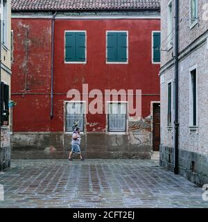 Atmosfera intorno al Festival Internazionale del Cinema di Venezia lunedì 7 settembre 2020 ai Giardini della Biennale di Venezia. Un uomo che cammina per le strade bagnate. Foto di Julie Edwards. Foto Stock