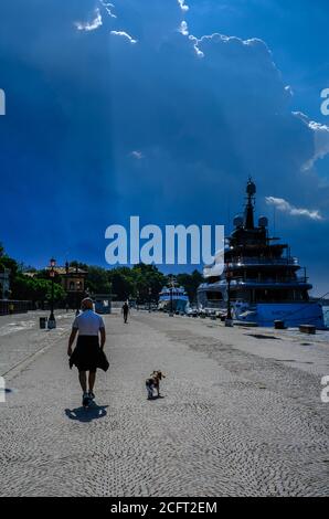 Atmosfera intorno al Festival Internazionale del Cinema di Venezia lunedì 7 settembre 2020 ai Giardini della Biennale di Venezia. Un uomo che cammina il suo cane sul lungomare sulle strade bagnate. Foto di Julie Edwards. Foto Stock