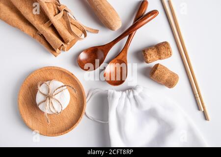 Accessori da cucina riciclato ecocompatibili - sacchetti biodegradabili e utensili in legno. Concetto di zero sprechi su sfondo bianco. Foto Stock