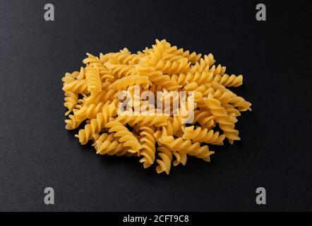 Pasta di fusilli grezza isolata su fondo nero Foto Stock