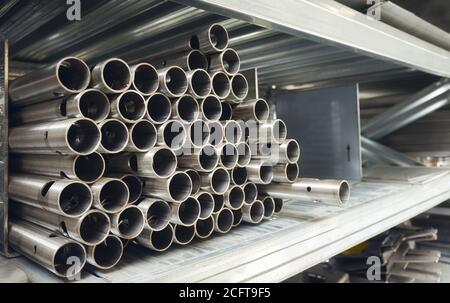 Tubi in acciaio su un ripiano, fuoco selettivo. Foto Stock