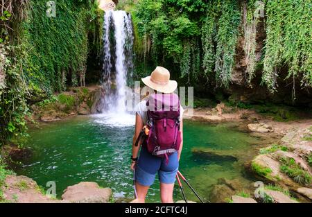 Escursionista giovane donna matura e cascata. Foto Stock