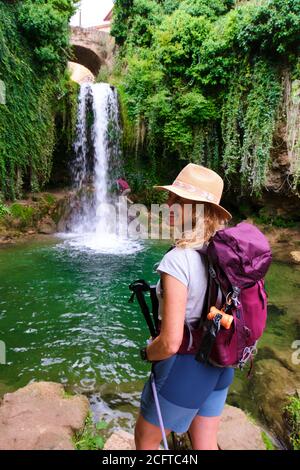 Escursionista giovane donna matura e cascata. Foto Stock