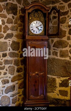 Antico orologio in bronzo vintage e utensili su mensola in legno, fondo parete in pietra. Concetto di antiquariato. Foto Stock