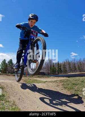 Un ragazzino (8 anni) saltando sulla sua mountain bike Foto Stock