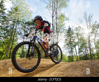 Un ragazzino (8 anni) saltando sulla sua mountain bike Foto Stock