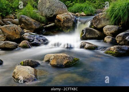 Tempo di esposizione di una cascata tra rocce bagnate Foto Stock