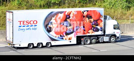 Vista laterale Tesco supermercato catena di approvvigionamento alimentare business store consegna marchio di autocarri e pubblicità grafica di frutta sulla guida di rimorchi Sull'autostrada del Regno Unito Foto Stock