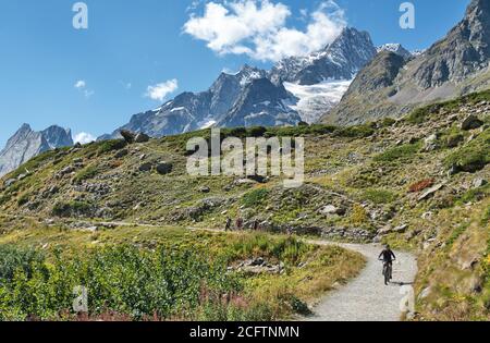 Persone che praticano sport dal massiccio del Monte Bianco. Vista panoramica sulla Val Veny e sul Lago di Combal in estate, Courmayeur, Aosta, Italia Foto Stock