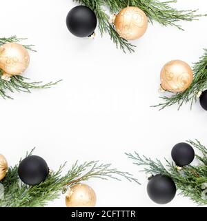 Composizione cornice Natale o anno nuovo. Palle dorate e nere di Natale e rami di abete su sfondo bianco. Vacanze. Vista dall'alto. Disposizione piatta Foto Stock