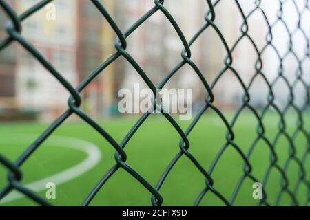 Recinzione di rete primo piano su uno sfondo di un campo di calcio Foto Stock