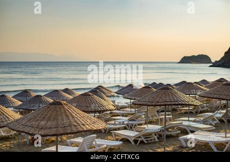 Ombrelloni e sdraio con mare e cielo serale sullo sfondo. Foto Stock