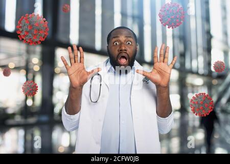 Il medico ha paura a causa di un attacco di virus codiv19. Sfondo ciano Foto Stock