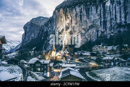 incredibile villaggio turistico alpino di notte in inverno con famoso chiesa e cascata di Staubbach Lauterbrunnen Svizzera Europa Foto Stock