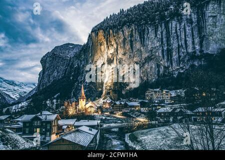 incredibile villaggio turistico alpino di notte in inverno con famoso chiesa e cascata di Staubbach Lauterbrunnen Svizzera Europa Foto Stock