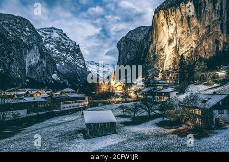 incredibile villaggio turistico alpino di notte in inverno con famoso chiesa e cascata di Staubbach Lauterbrunnen Svizzera Europa Foto Stock