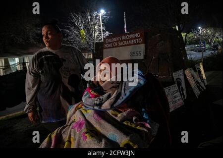 Sacramento, California, Stati Uniti. 14 Feb 2020. FELICIA BRENT-VELASQUEZ, 18 anni, è impacchettata in coperte nella sua sedia a rotelle come lei si unisce a sua madre FELICIA CLARK, 36 anni, in protesta al di fuori del Children's Receiving Home di Sacramento. "È difficile vedere le cose che vedo là fuori, ma è per questo che continuo a tornare", ha affermato Clark. "Voglio distinguersi per un solo venerdì e non vedere nulla. Non voglio vedere bambini, persone che fanno ciò che dovrebbero fare, bambini che lasciano per andare a fare attività, genitori che entrano e felici di far parte di qualche processo." (Credit Image: © Renee C. Byer/Sacramento Foto Stock