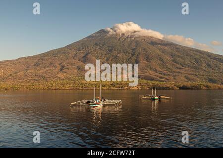 Isola vulcanica indonesiana dietro un sipario di nuvole, Isole Sunda, Indonesia Foto Stock